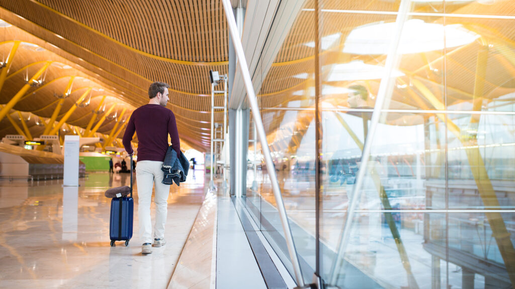 Turista camina por la terminal de Madrid Barajas. Envato.