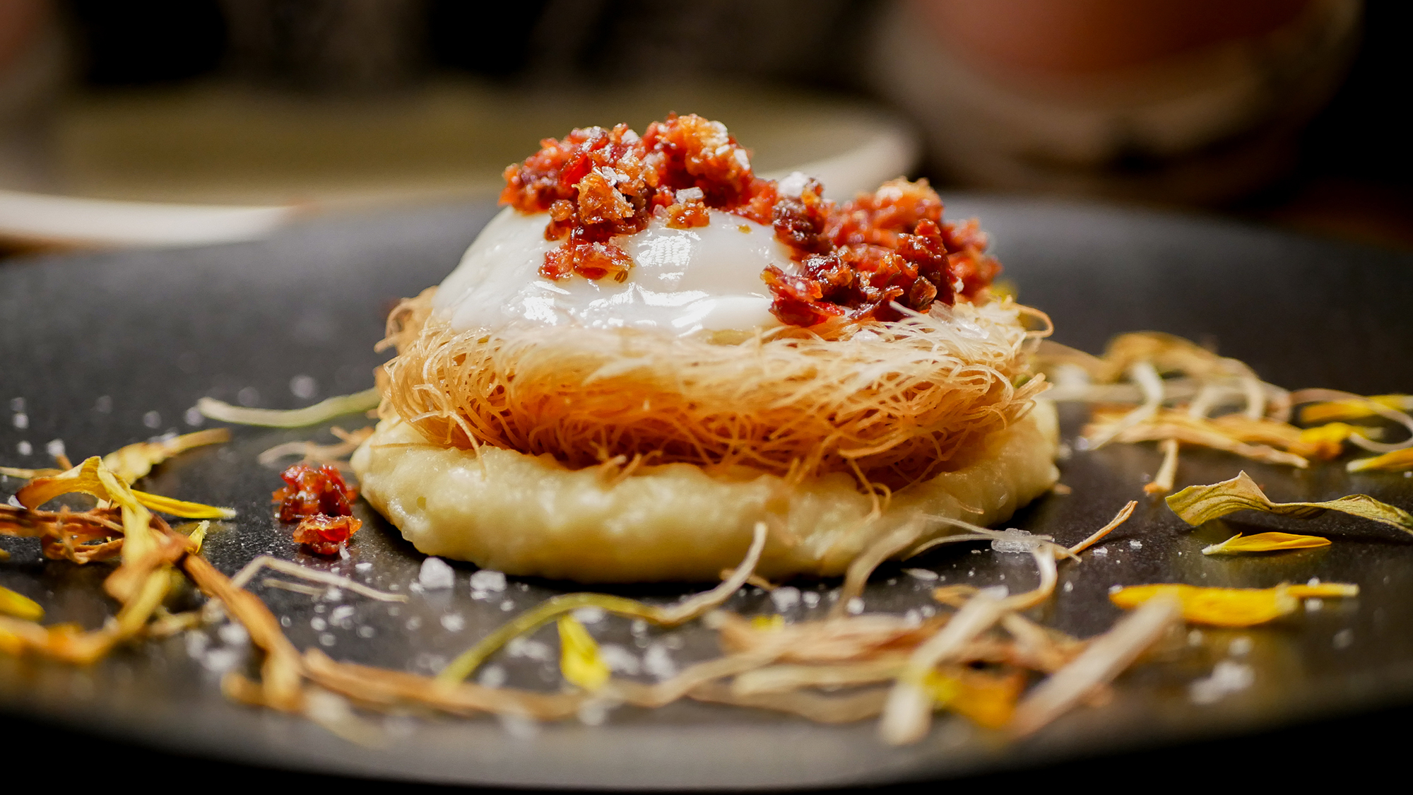Huevo cocido a baja temperatura sobre suave parmentier de puerros, con nido crujiente de trigo y chips de jamón inbérico