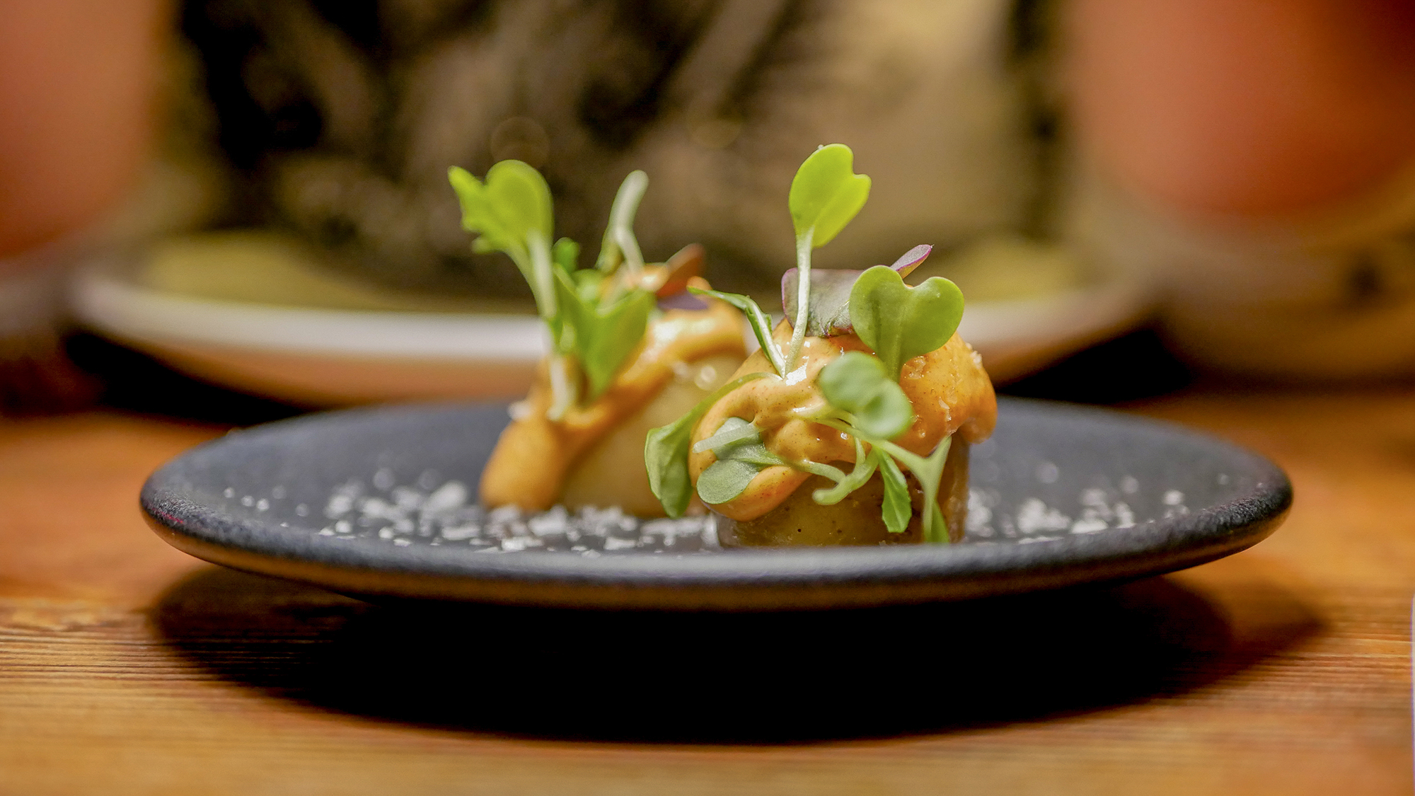 Versión de las patatas bravas con patata baby, salsa brava y brotes