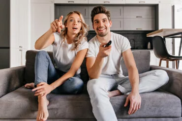 Una pareja disfrutando de sus series. Fotografía de Envato