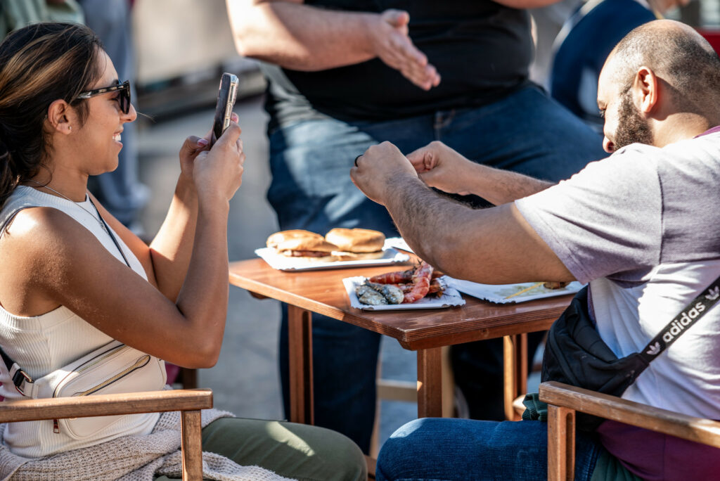 Dos visitantes inmortalizando la tapa que van a consumir