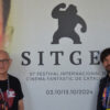 Mario Herrera y Santi Serrano, de Pánico en la sala, frente al cartel de la presente edición del Festival de Sitges.