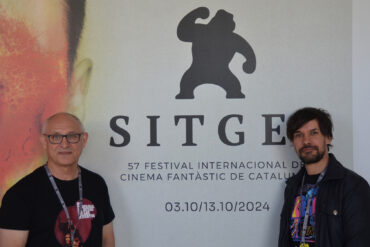 Mario Herrera y Santi Serrano, de Pánico en la sala, frente al cartel de la presente edición del Festival de Sitges.