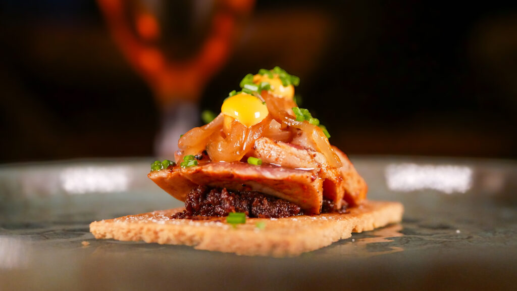 Lomo de atún a la llama sobre tostada de almendra, pasta de tomate semiseco, cebolla al jerez y mayonesa de ajada del restaurante Arume