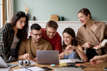 Un grupo de jóvenes reunidos frente a un ordenador. Freepik