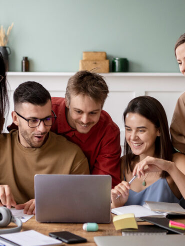 Un grupo de jóvenes reunidos frente a un ordenador. Freepik