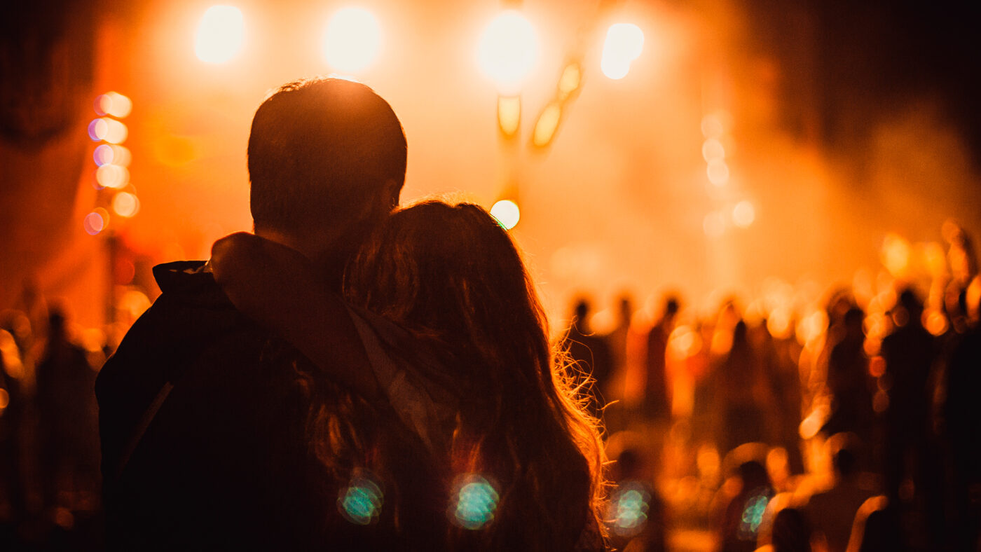 Pareja disfrutando de un concierto abrazados