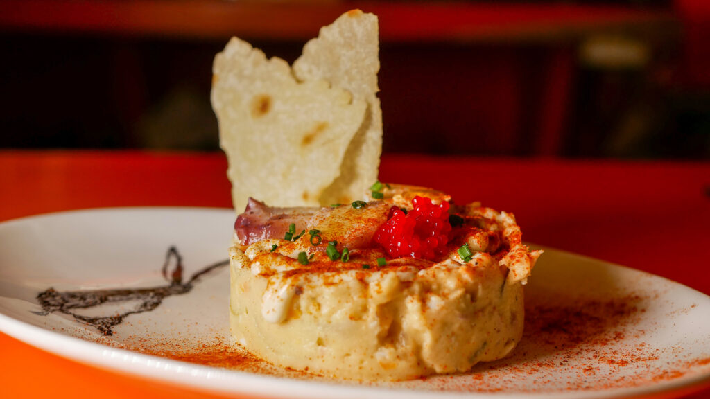 Tapas Ensaladilla de pulpo con kimchi, zanahoria, piparras y olivas, huevas de pescado y crujiente de pan carasatu de Las Fernández