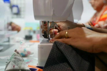 Unas manos cosiendo con una maquina de coser