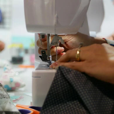 Unas manos cosiendo con una maquina de coser