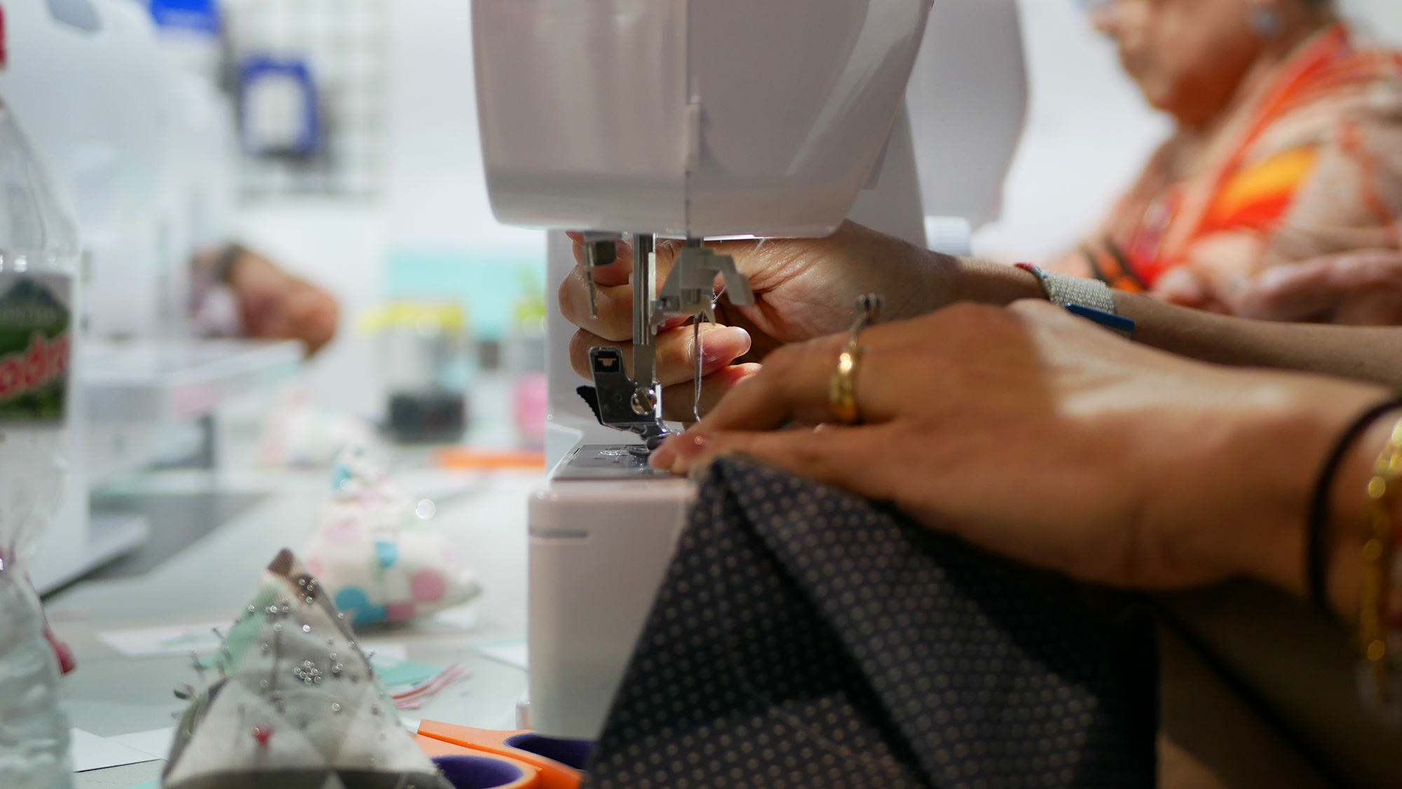 Unas manos cosiendo con una maquina de coser