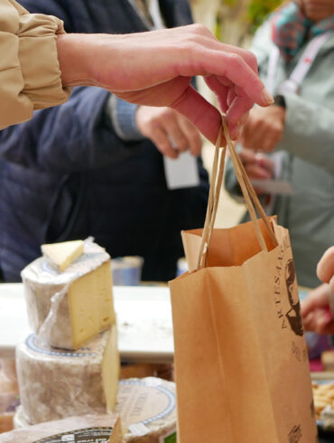 Una comerciante extiende una bolsa en una parada del Mercado de la tierra