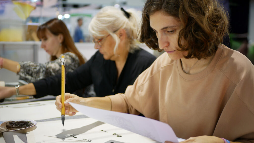 Unas visitantes realizando un taller de pintura con tinta china