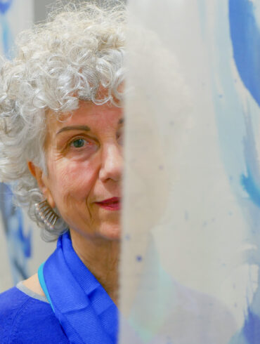 La artista Kima Guitart posando junto a una de su obra. Fotografía de Man Hoh Tang