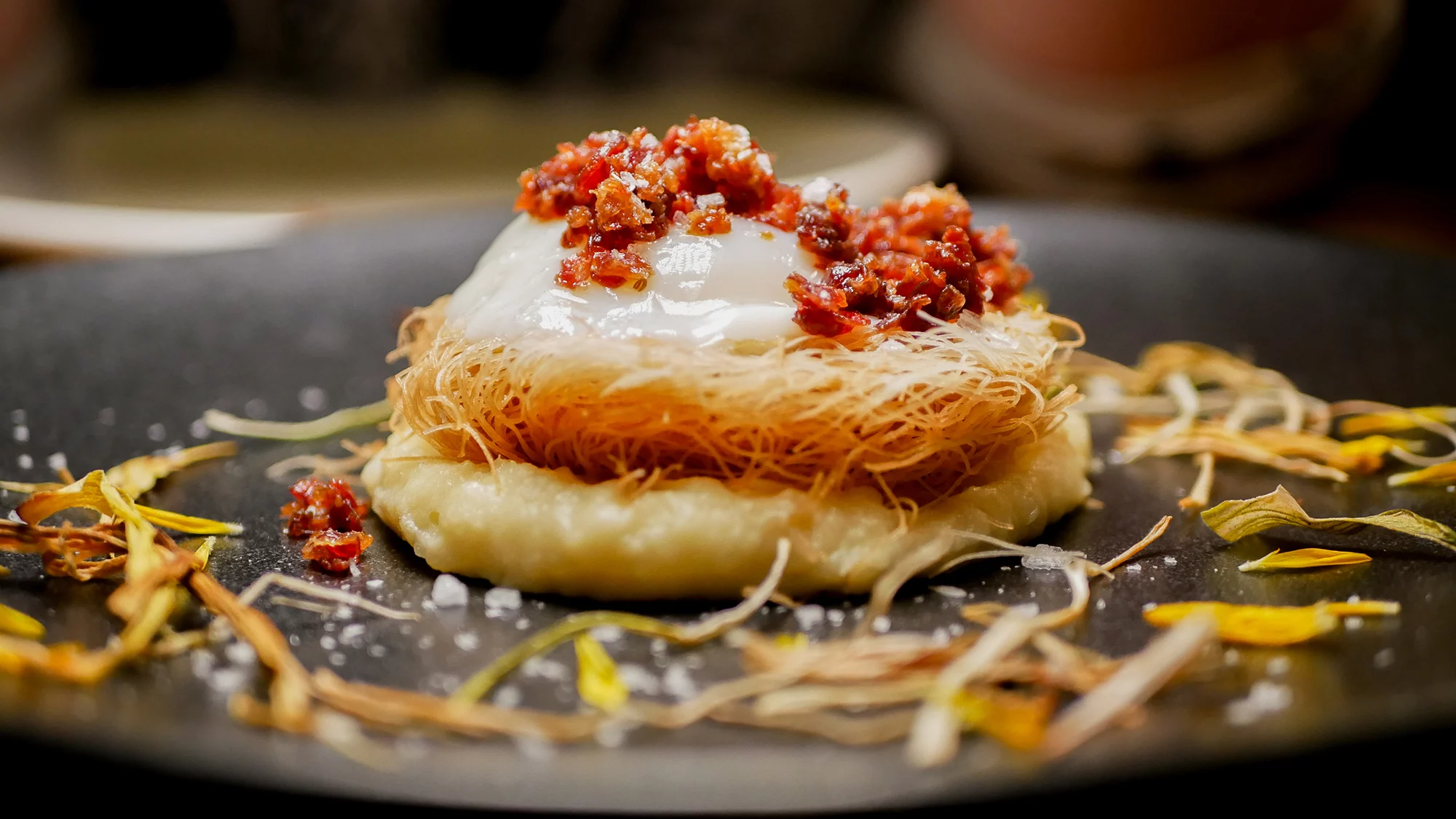 Huevo cocido a baja temperatura sobre suave parmentier de puerros, con nido crujiente de trigo y chips de jamón inbérico