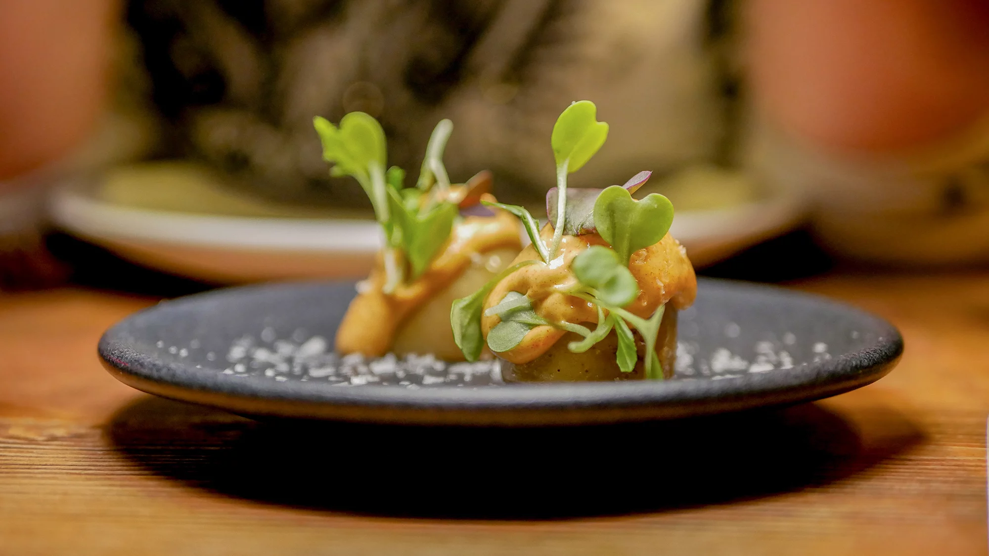 Versión de las patatas bravas con patata baby, salsa brava y brotes