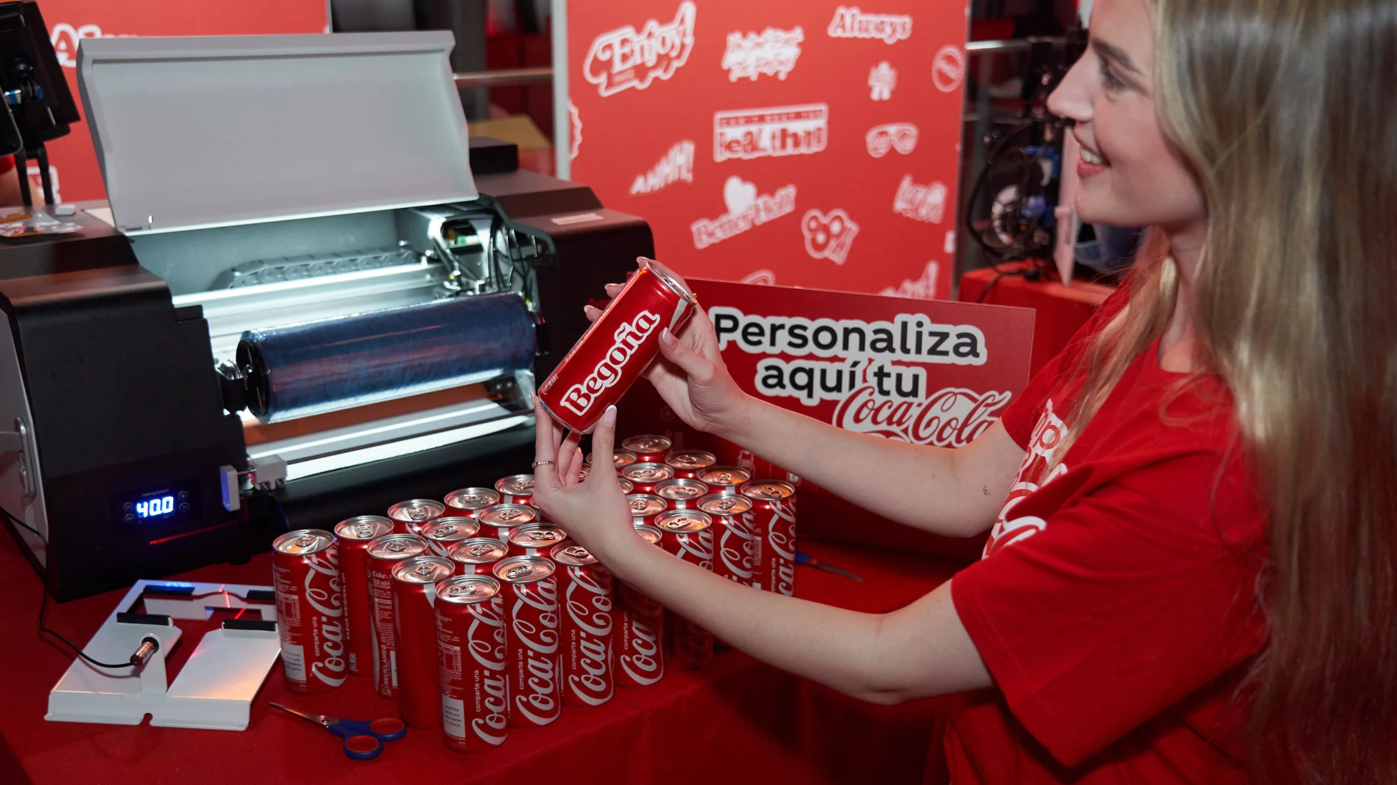 Una trabajadora muestra alguna de las latas personalizadas