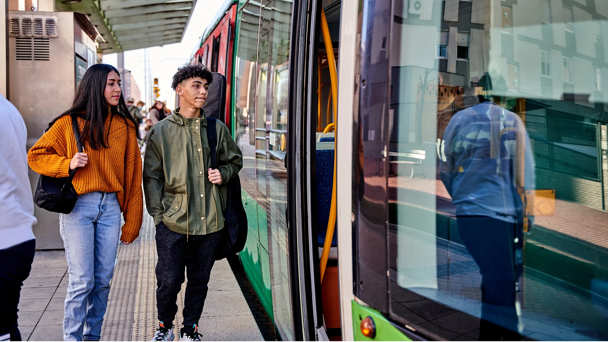 Dos jóvenes accediendo a un tranvía en Barcelona