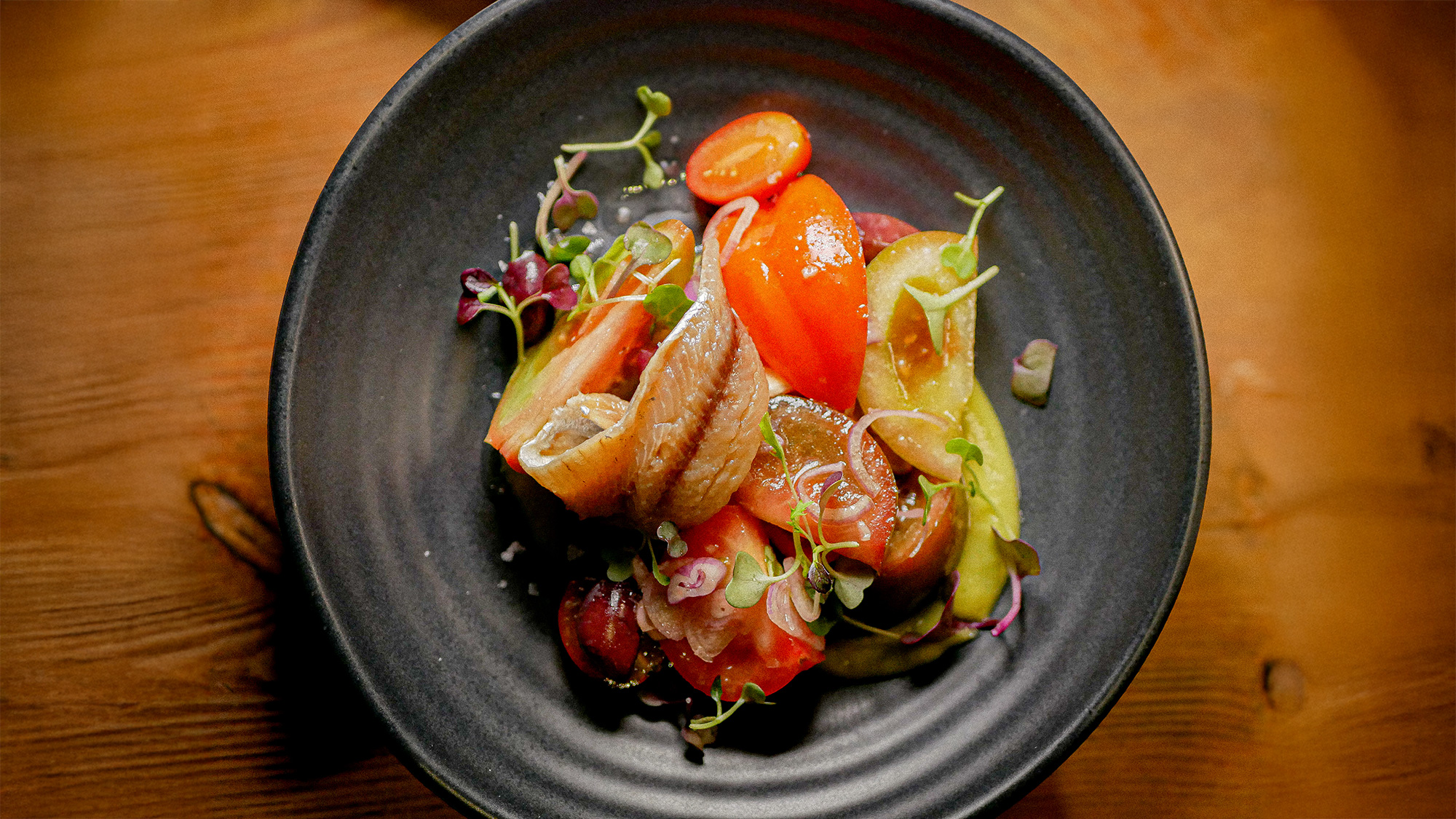 Selección de tomates km 0 con sardina ahumada, crema de guacamole y piparra, oliva de Kalamata y chalota encurtida. Restaurante Arcano