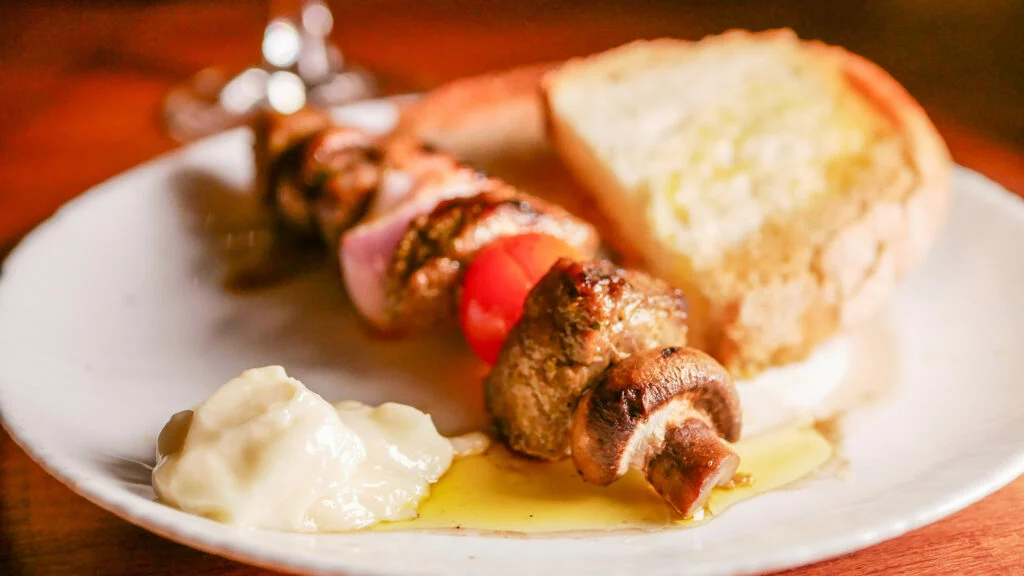 TABERNA D'EN RUBEN | Brocheta de carne adobada, tomate cherry y cebolla, acompañada de pan de payés y alioli.