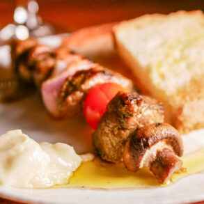 TABERNA D'EN RUBEN | Brocheta de carne adobada, tomate cherry y cebolla, acompañada de pan de payés y alioli.