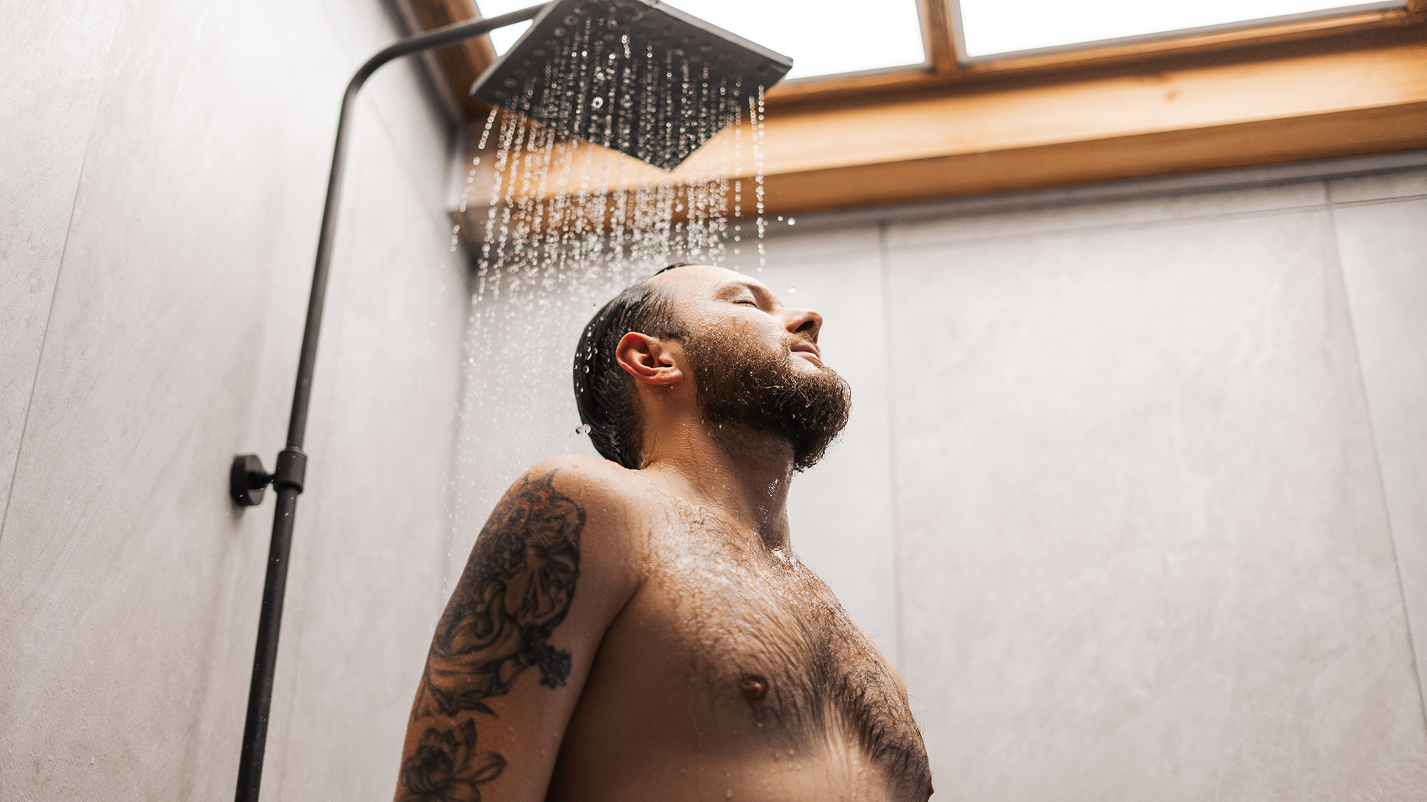 Hombre disfrutando de una ducha. Fotografía de Envato