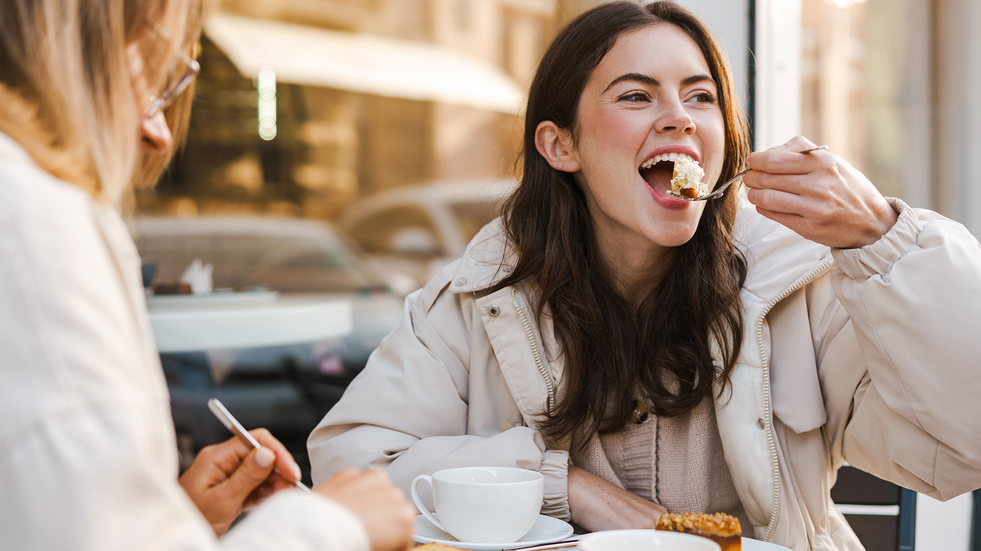 Dos mujeres comiendo pastel de queso. Fotografía de Envato
