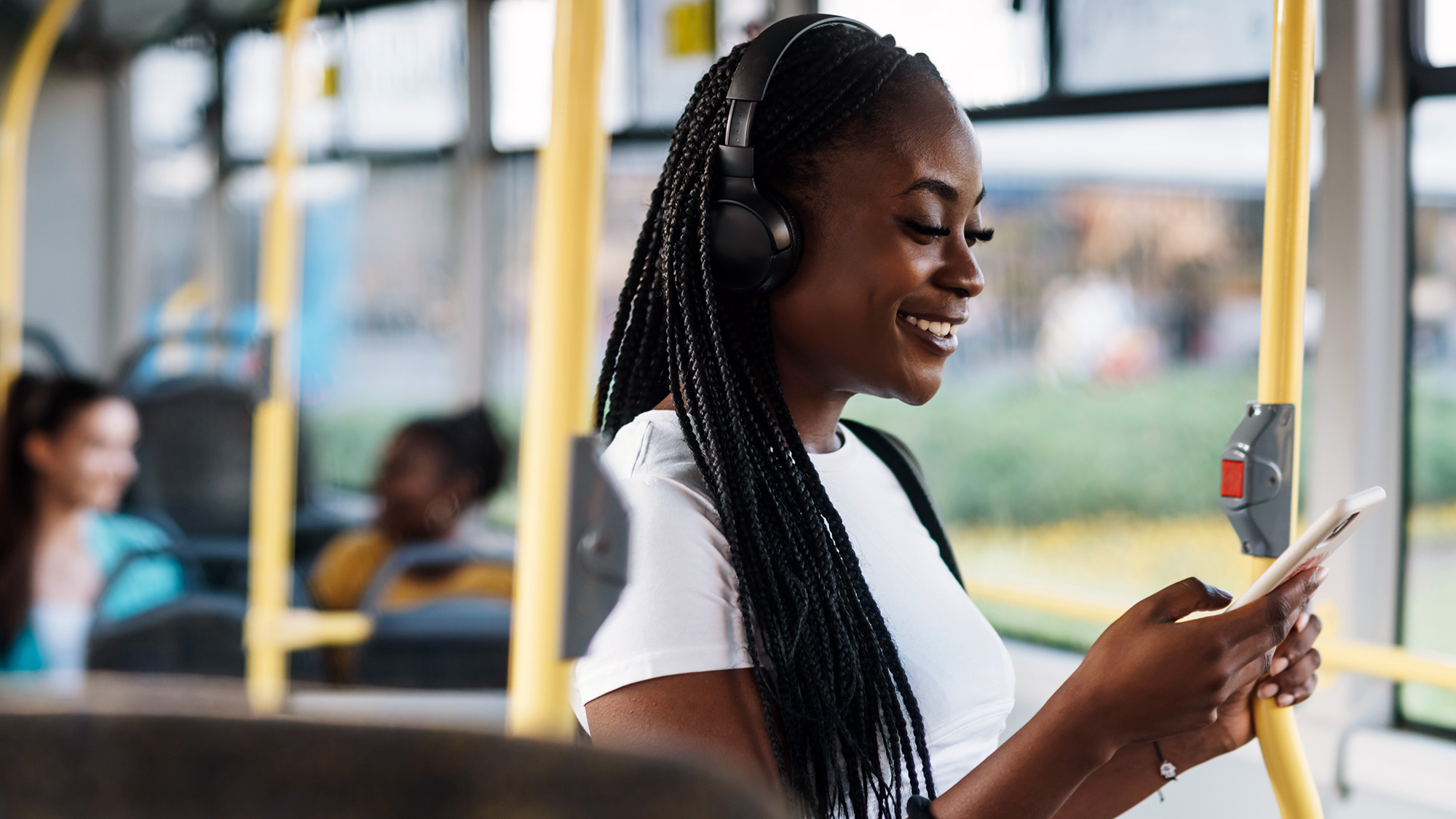 Mujer disfrutando de un podcast en el autobús. Fotografía Envato