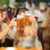 Dos chicas brindando con grandes jarras de cerveza en el Beer-Fest del Poble Espanyol. Fotografía de Julieta Feroz