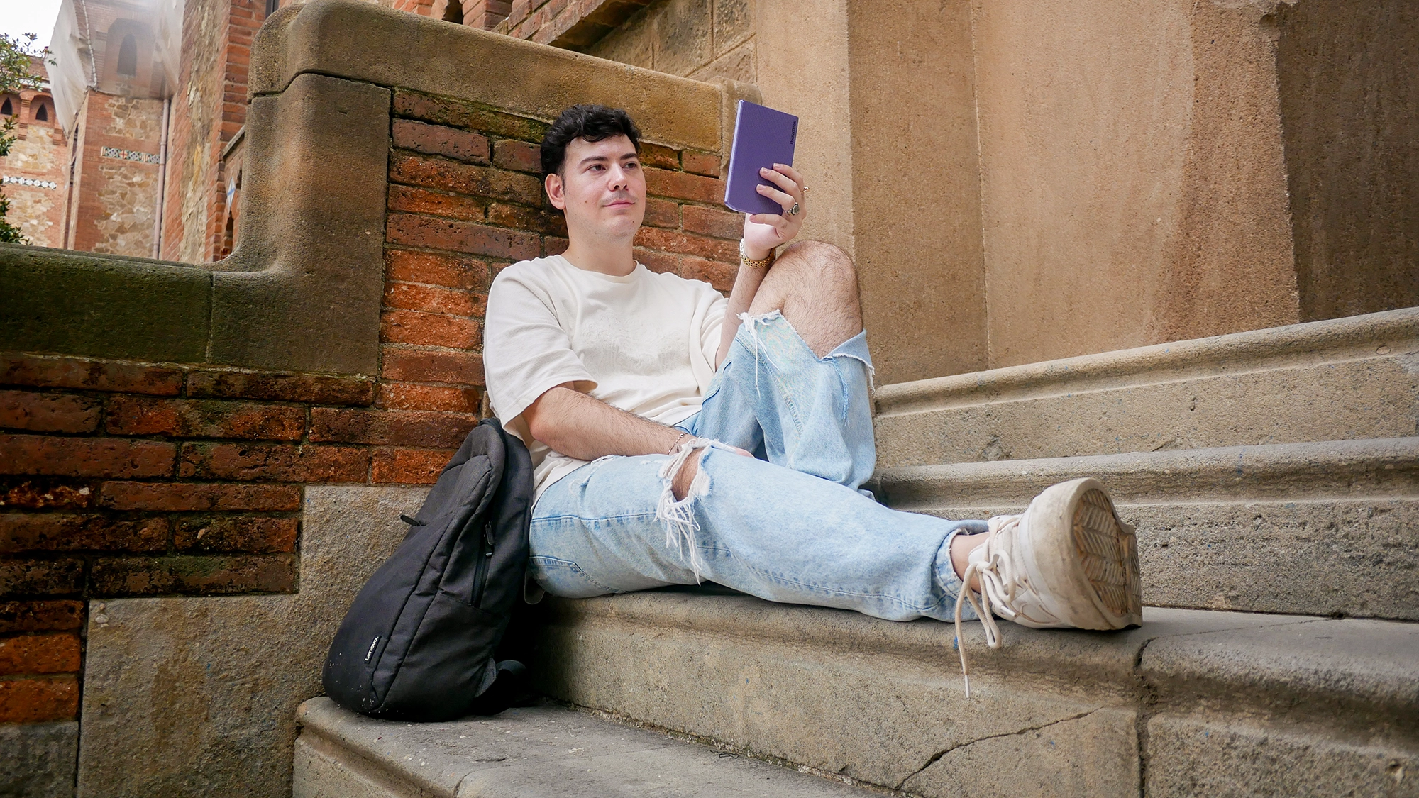 Matías Domañski disfrutando de la lectura en las escaleras de la facultad con su dispositivo PocketBook Verse Pro Color