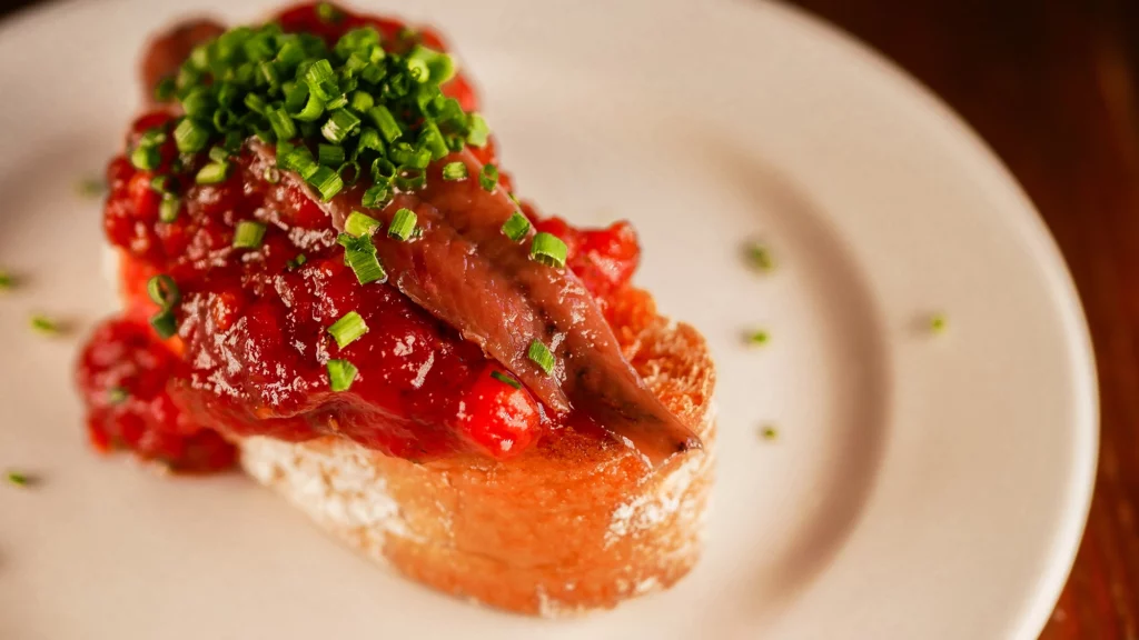 Tosta de anchoa de l'Escala con tomate confitado de la Prudencia del Raval
