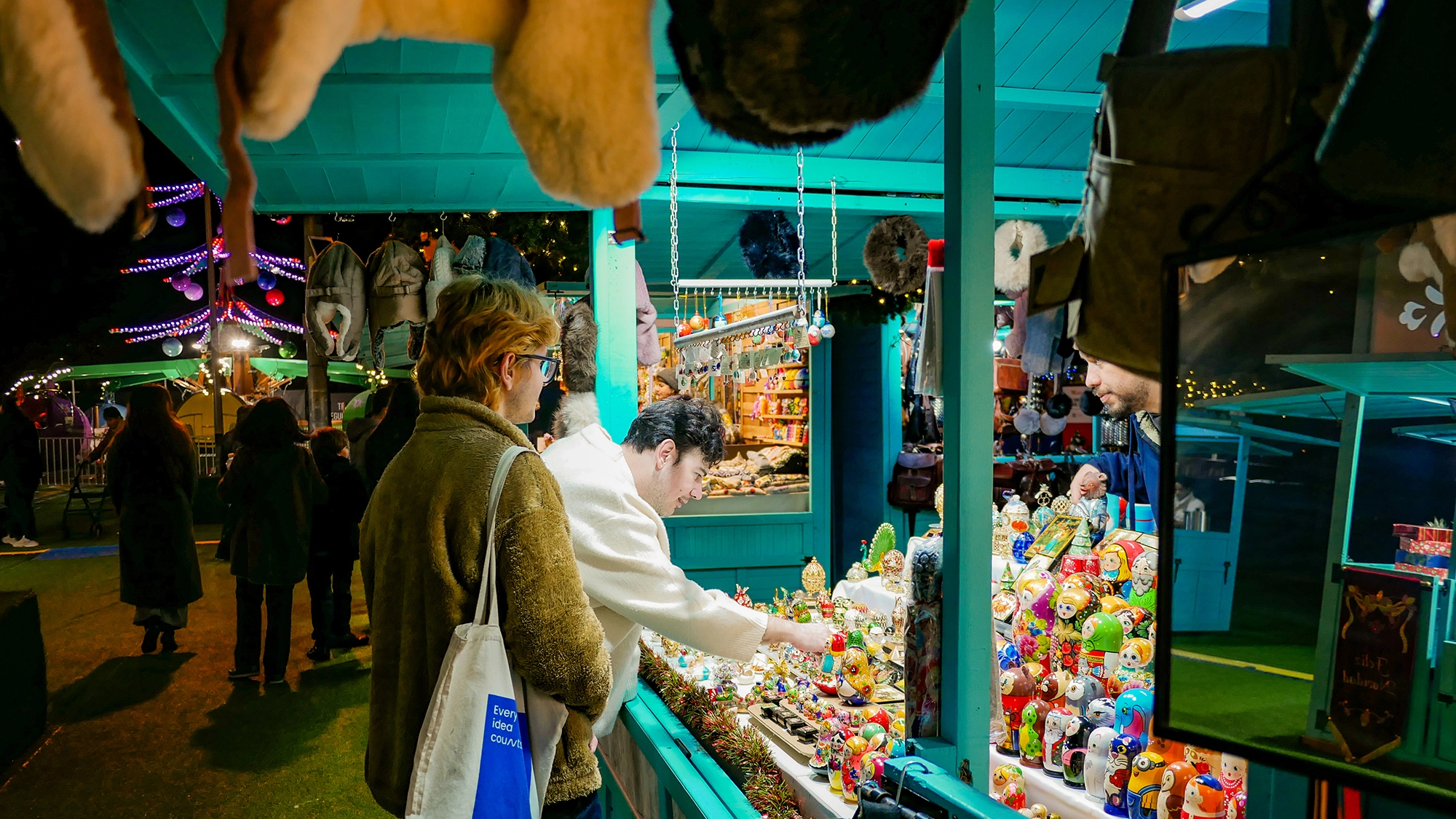 Una pareja de amigos mirando un puesto en el mercadillo navideño del Westfield La Maquinista