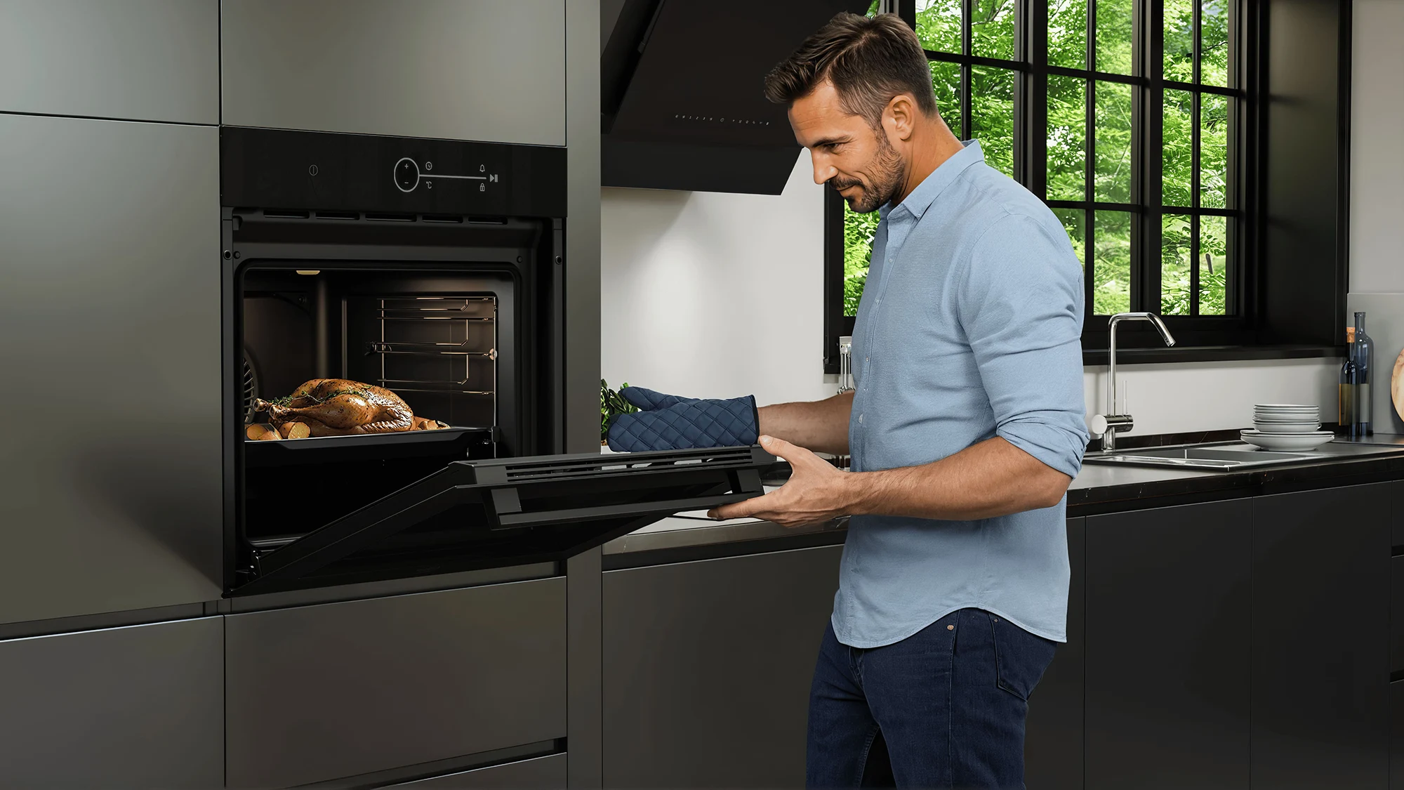 Hombre con la puerta del horno de la colección DeepBlack de Beko abierta revisando el estado de un pavo al horno