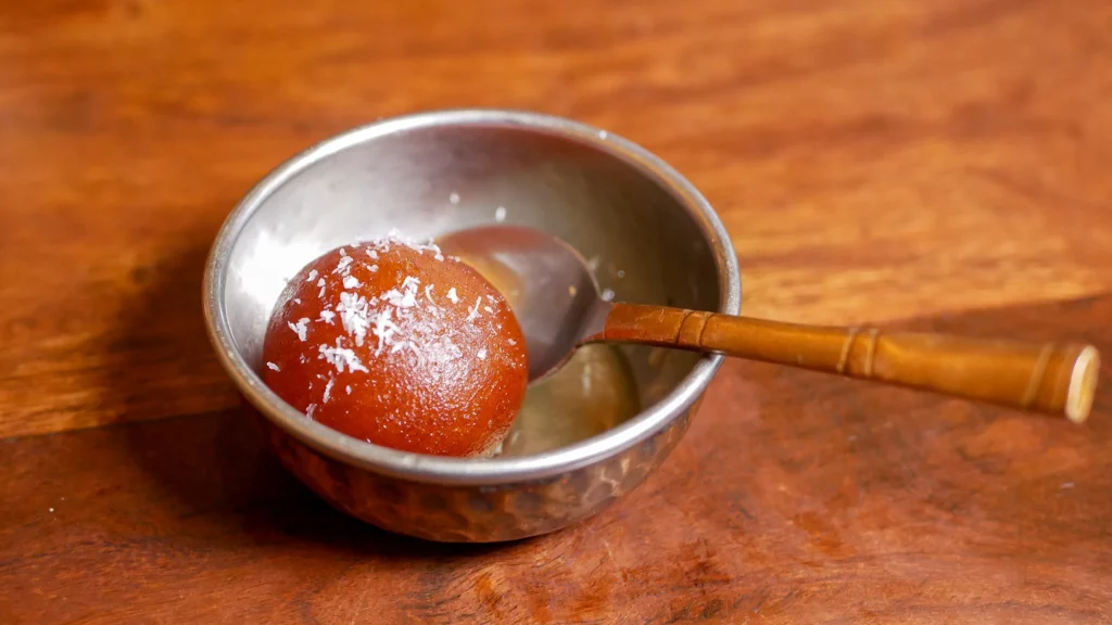 Gulab Jamun, pequeñas bolitas de leche fritas que se sirven bañadas en un delicado jarabe de azúcar aromatizado