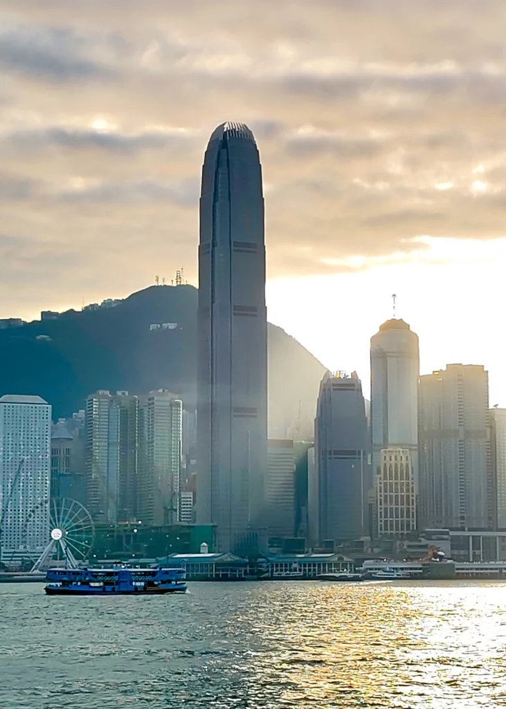 Luces y reflejos al atardecer en Victoria Harbour, con el Bank of China Tower como protagonista del horizonte.