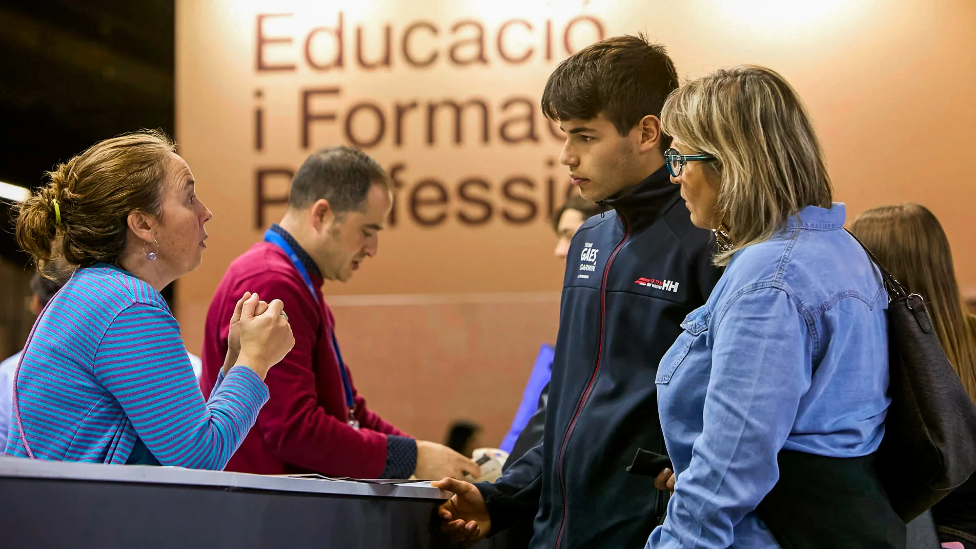 Un visitante recibiendo asesoramiento en un stand del Saló de l'ensenyament