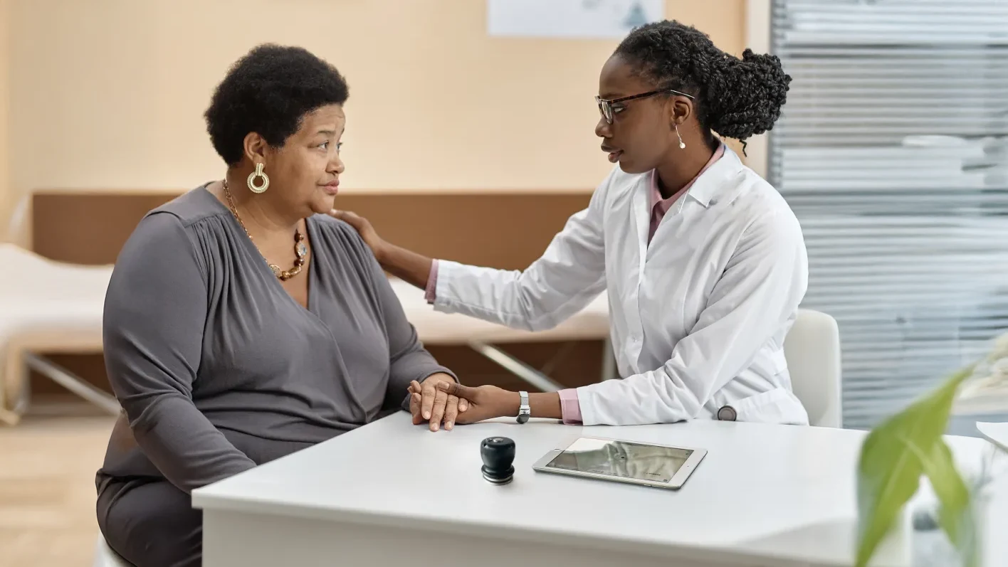 Medica visita a una paciemnte, sobre la mesa está el estetoscopio digital con tecnología de IA y una tablet para ver los resultados