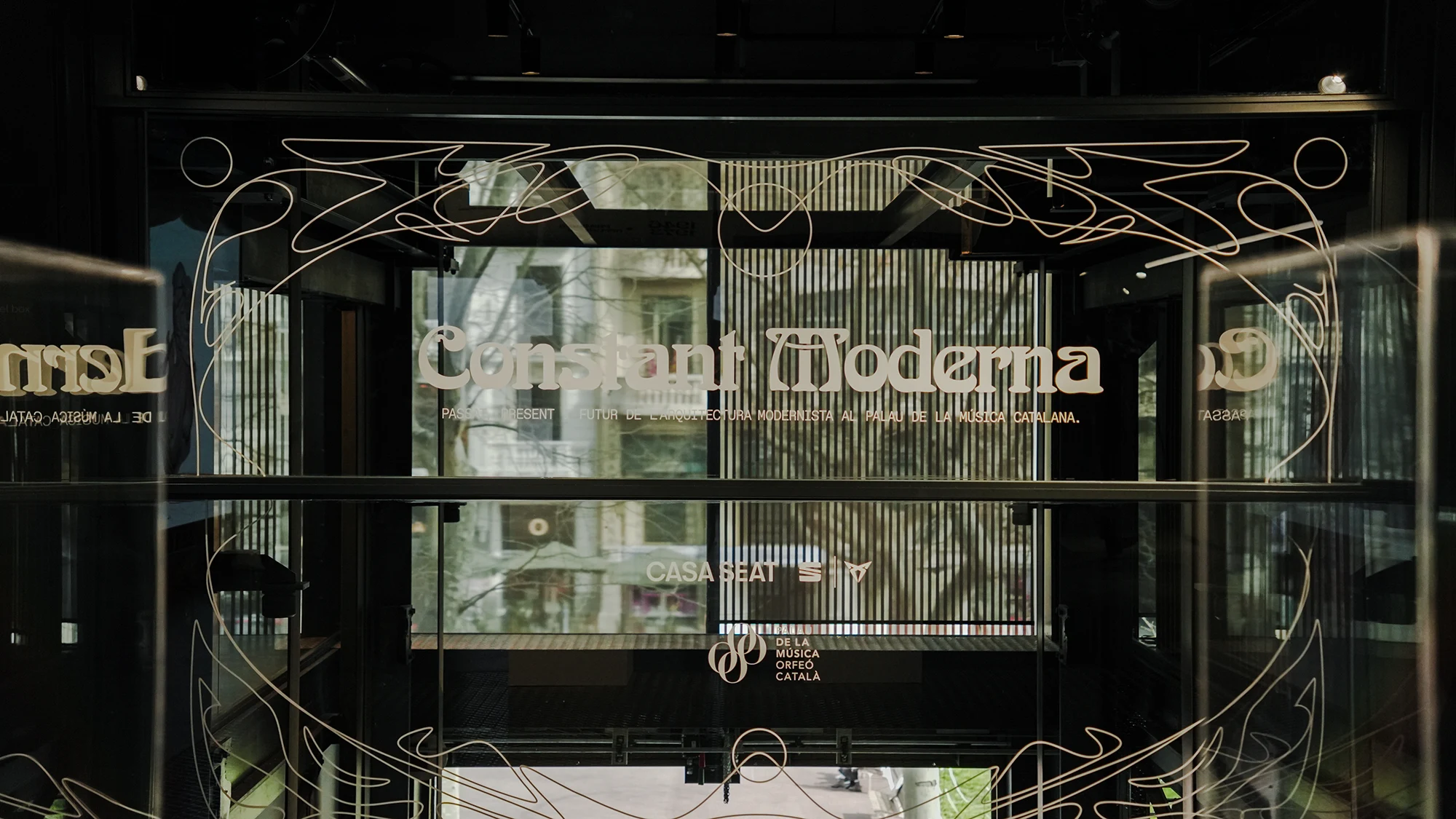 Vista de la puerta con un motivo en vinilo que muestra el nombre de la exposición "Constante Moderna"