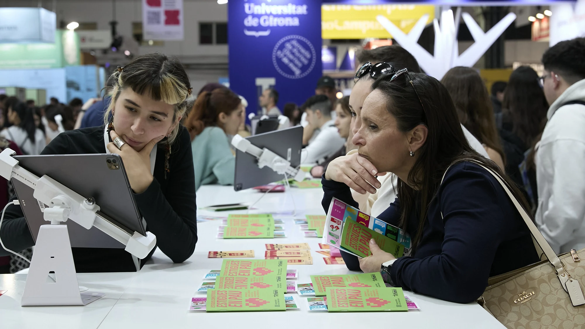 Una visitante recibiendo asesoramiento en un stand del Saló de l'ensenyament