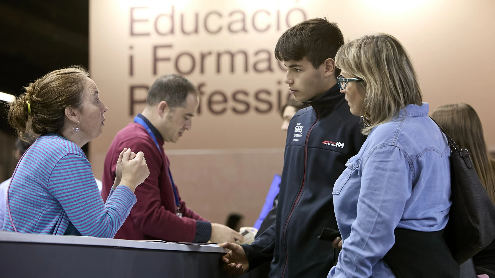 Un visitante recibiendo asesoramiento en un stand del Saló de l'ensenyament
