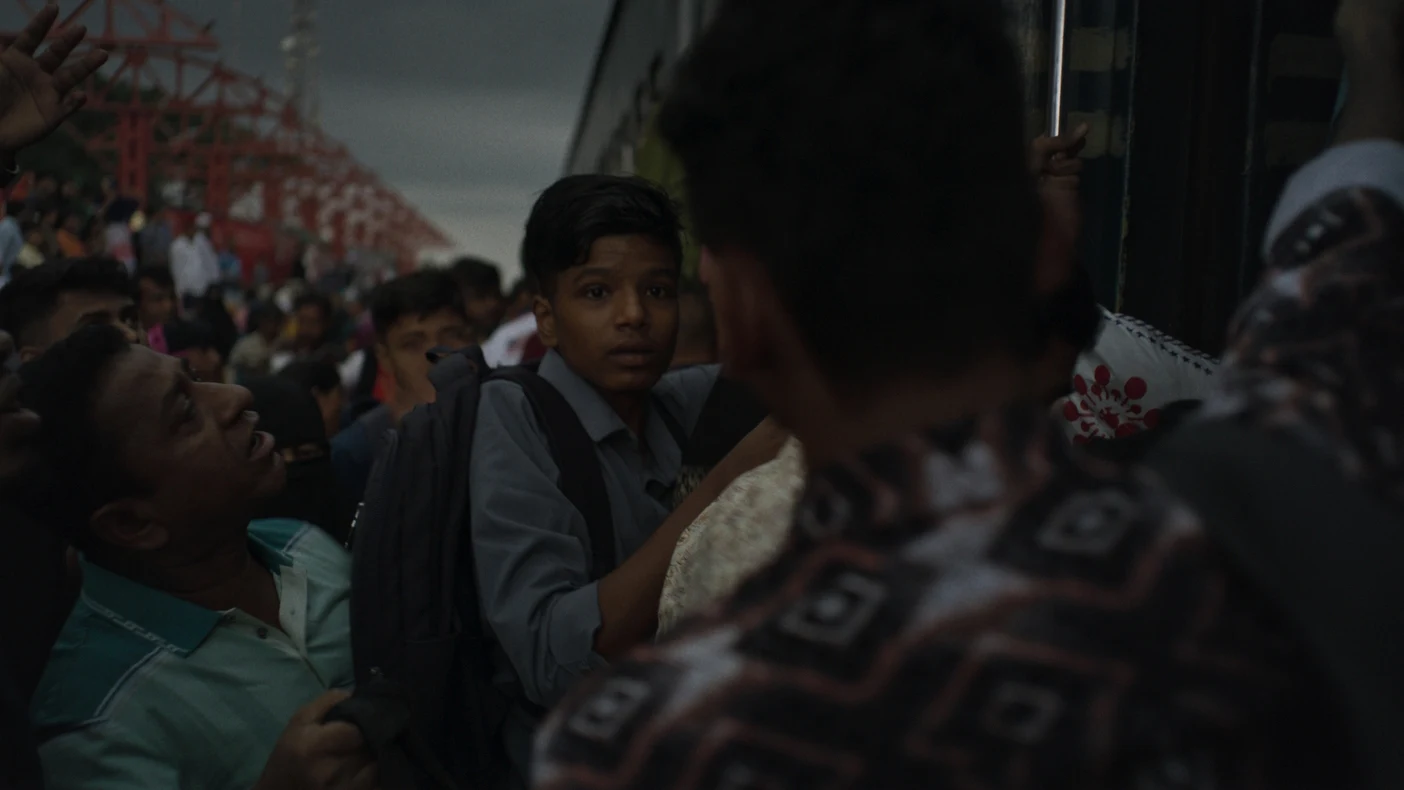 Fotograma de Black Water. Un niño entrando a un tren repleto de personas.