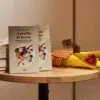 Imagen detalle de libros y rosas sobre una mesa pequeña de Starbucks
