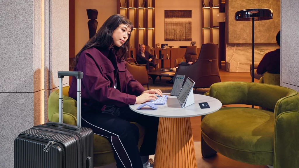 Una viajera consultando sui correo con su ratón plegable Mobi Fold