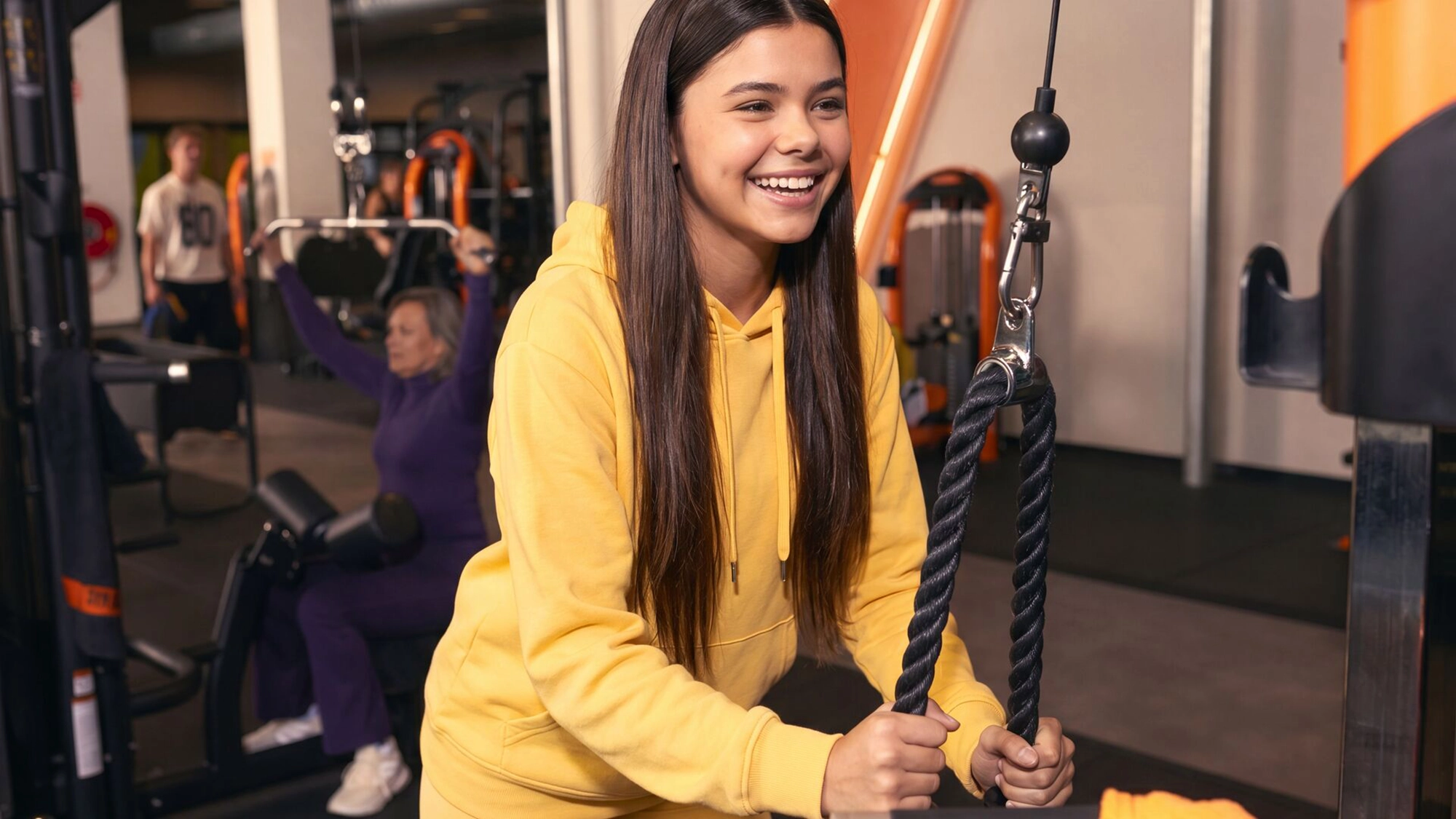 Una chica entrenando fuerza en una maquina del Basic Fit