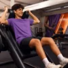 Un joven entrenando peso en una máquina del Basic Fit
