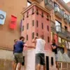 Vecinos de la calle Alcolea de Dalt sosteniendo el cuerpo central de una torre veneciana. Fotografia de Man Hoh Tang