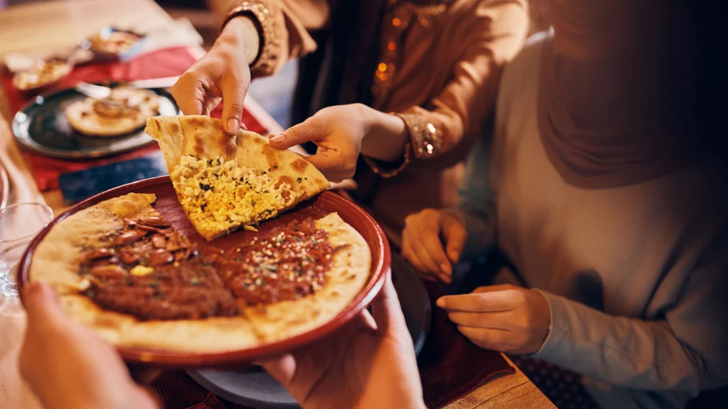 Familia compartiendo un trozo de pizza en casa, fotografia de Envato